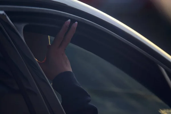 Female hand outside an open car window