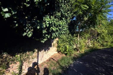 Gün batımında parktaki tuğla duvarın yanında çakıl yolu.