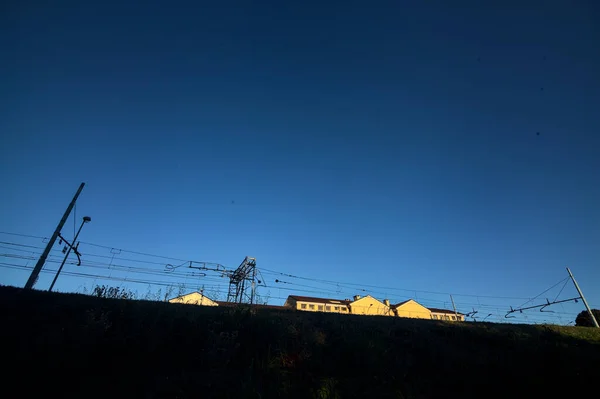 日没時に公園内の鉄道線路の隣の道 — ストック写真