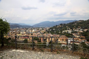 Bulutlu bir günde, bir dağ sırasının yanında bir şehir bulunan panoramik bir nokta