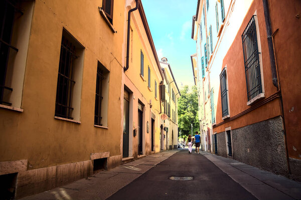 Narrow street in the shade between tall buildings in an italian town