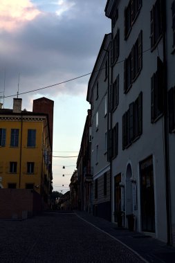 Dükkanları ve insanların gün batımında gezindiği bir İtalyan kasabası.