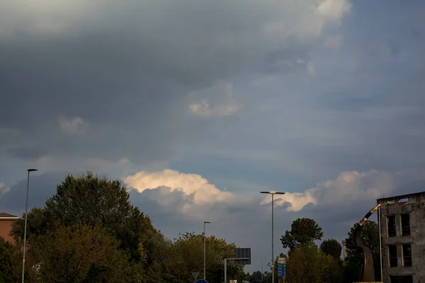 Bewolkte Zonsondergang Hemel Omlijst Door Bomen Een Gebouw — Stockfoto