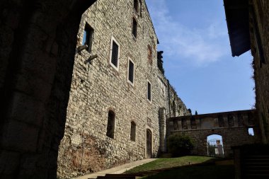 İç avluda kısmen gölgede, şatoda merdiven var.