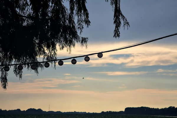 Lichter Hängen Einem Seil Mit Dem Sonnenuntergangshimmel Als Hintergrund — Stockfoto