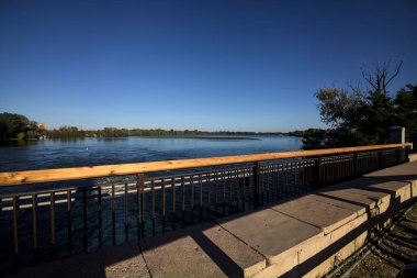 Gün batımında bir gölün üzerindeki köprüde