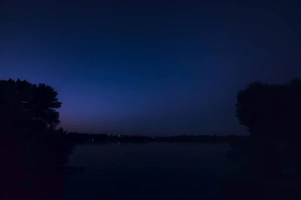 Jezioro Drzewami Nad Brzegiem Zachodzie Słońca Widziane Góry — Zdjęcie stockowe