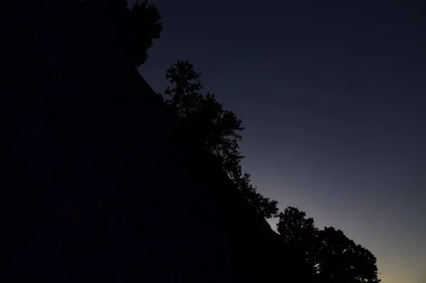 Sonnenuntergang Himmel Mit Silhouette Von Bäumen Und Einer Mauer — Stockfoto