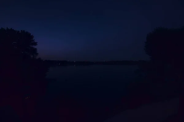 上から見た日没時に海岸沿いの木々と湖 — ストック写真