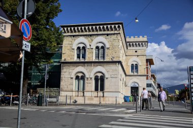 Güneşli bir günde Brescia 'da dükkanları ve restoranı olan bir sokak.