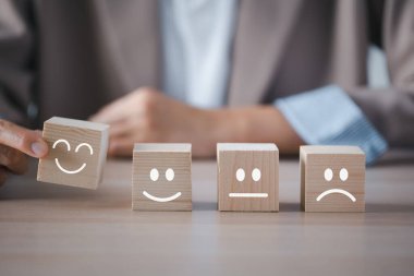 Yakın plan iş kadını eli ahşap küpten mutlu duygu yüz seçerek tatmin araştırması için masaya yerleştirildi, zihinsel sağlık değerlendirmesi