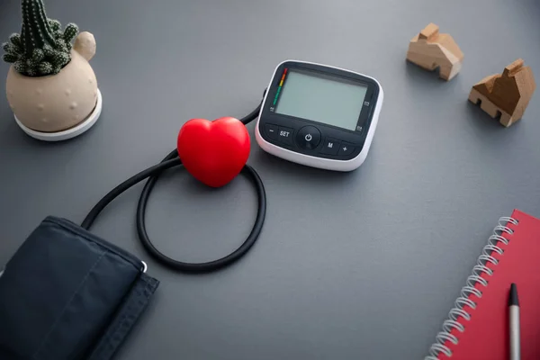 blood pressure monitor machine for self blood pressure and heart rate measurement with red heart, healthcare and medical concept