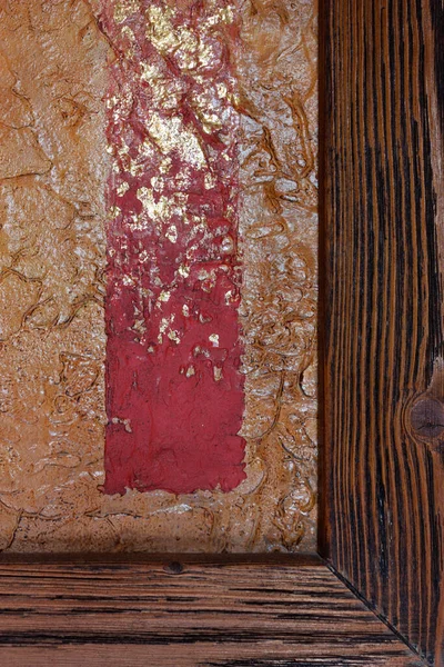 Abstract texture. Red strip with golden spots on an orange background with a wooden board.