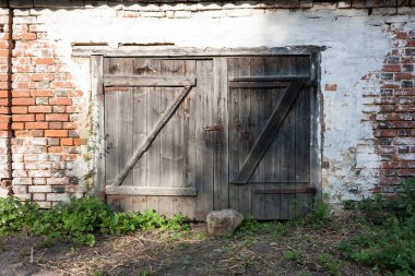 Kırmızıboya lekeli kırmızı tuğladan yapılmış eski ahşap bir kapı..