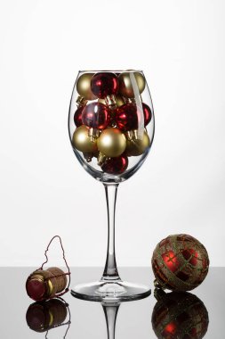Küçük altın ve kırmızı Noel toplarıyla dolu bir şarap kadehiyle dolu modern bir Noel hayatı..