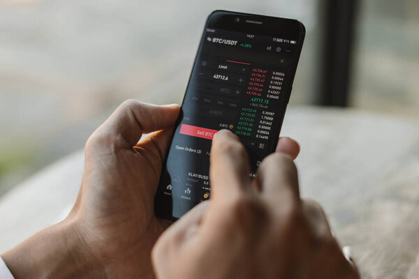 Close up of hands trader investor discussing and analysis bitcoin graph on smartphone. businessman using mobile phone app analytics for cryptocurrency. Bitcoin and Cryptocurrency investment concept.