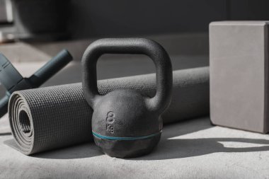 Kettlebell ve yoga minderi evde yerde. spor aletleri.