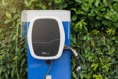 Otoparktaki elektrikli araba şarj istasyonu EV bataryası için. Yeşil güç ve gelecekteki ulaşım teknolojisi kavramı.