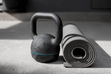 Kettlebell ve yoga minderi evde yerde. spor aletleri.