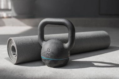 Kettlebell ve yoga minderi evde yerde. spor aletleri.