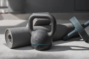 Kettlebell ve yoga minderi evde yerde. spor aletleri.