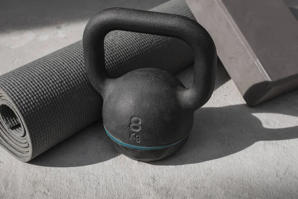 Kettlebell ve yoga minderi evde yerde. spor aletleri.