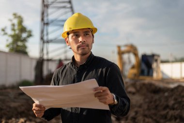 İnşaat alanında çalışan mühendis. İnşaat alanında çalışan genç bir işçi. Mühendislik ve İnşaat kavramı.