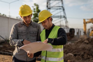 İnşaat alanında çalışan mühendisler. İnşaat yöneticisi ve mühendis inşaat sahasındaki proje hakkında toplantı ve tartışma.