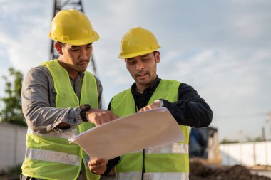 İnşaat alanında çalışan mühendisler. İnşaat yöneticisi ve mühendis inşaat sahasındaki proje hakkında toplantı ve tartışma.