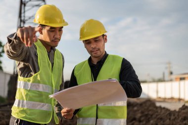 İnşaat alanında çalışan mühendisler. İnşaat yöneticisi ve mühendis inşaat sahasındaki proje hakkında toplantı ve tartışma.