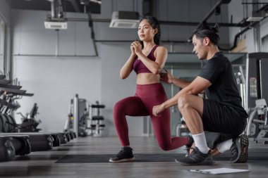 Asyalı kadın spor salonunda kişisel antrenörle egzersiz yapıyor. Asyalı sağlıklı kadın spor yapıyor spor salonunda kişisel koçla..
