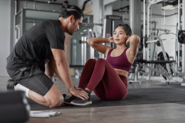 Spor salonunda kişisel antrenörle Asyalı kadın egzersizi. Şahsi koçla fitness antrenmanı yapan sağlıklı bir kadın..