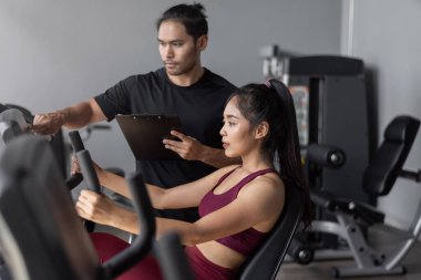 Spor salonunda kişisel antrenörle Asyalı kadın egzersizi. sağlıklı bir kadın kişisel koçla spor yapıyor..