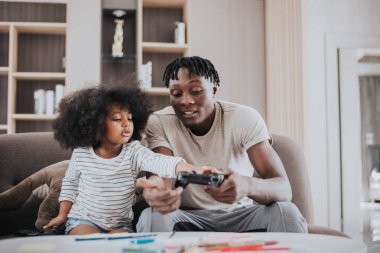 Mutlu aile evde eğleniyor. Küçük kızları olan Afrikalı bir baba evde birlikte oynuyor. Mutlu aile zamanları..