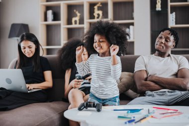 Mutlu Afrikalı aile evde birlikte eğleniyor. Afrikalı çocuklar oturma odasında ailesiyle oyun oynuyor. Mutlu aile zamanları..