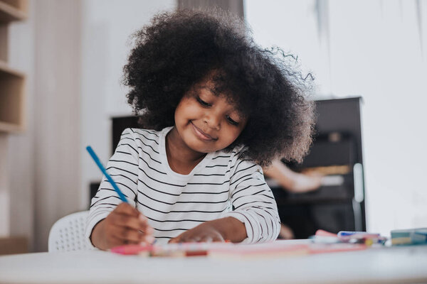 African little kid learning drawing with her mother. african kids smiling and drawing at home.