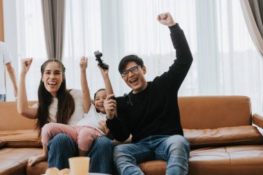 Mutlu aile evde eğleniyor. Asyalı aile evdeki oturma odasında oyun oynuyor. Mutlu aile kavramı.
