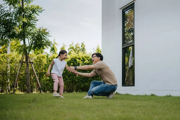 Family having fun time at home. Asian family with little kids daughter playing together in house backyard outside. Happy family time.