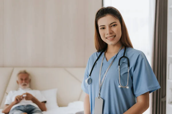 Asian nurse standing and smiling to  caring elderly man at home. young nurse helping senior man at home. Senior health care.