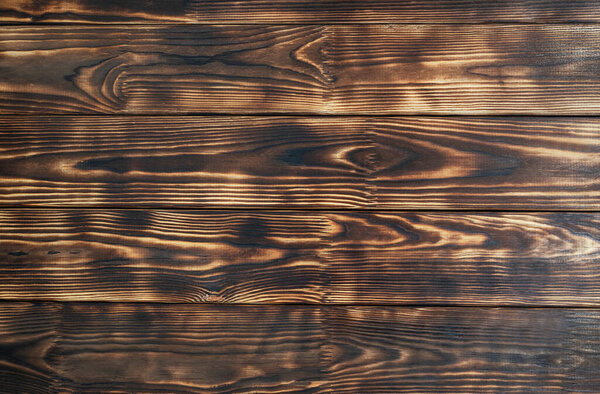 Dark brown boards with black streaks from firing. Natural boards. Wooden background. Textured wood. Top view