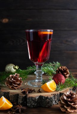 Şeffaf cam, kırmızı şarap, portakal, tarçın ve ahşap bir stantta yıldız anason karışımı.