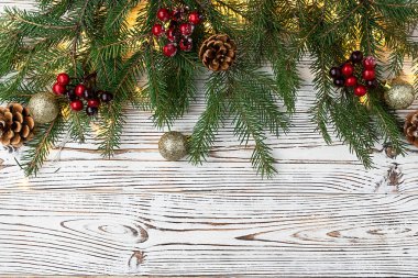 Yeni yıl arkaplanı, Noel kartı. Çelenkler, altın toplar, kozalaklar ve kırmızı böğürtlenlerle süslenmiş Firavun dalları. Üst görünüm, metin için boşluk