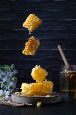 Pieces of honeycomb from which honey drips hang in the air