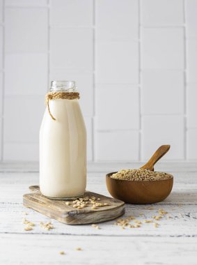 Kahverengi tahta üzerinde cam bir şişede arpa sütü