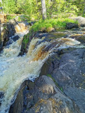 Karelia 'daki Tokhmayoki Nehri' ndeki Akhvenkoski şelalesinin üzerinden geçen yaya köprüsünün manzarası.