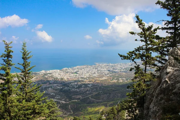 Kyrenia şehri ve Akdeniz 'deki Aziz Hilarion şatosuyla ağaçların ve taş duvarların arasına bakın. Kıbrıs.