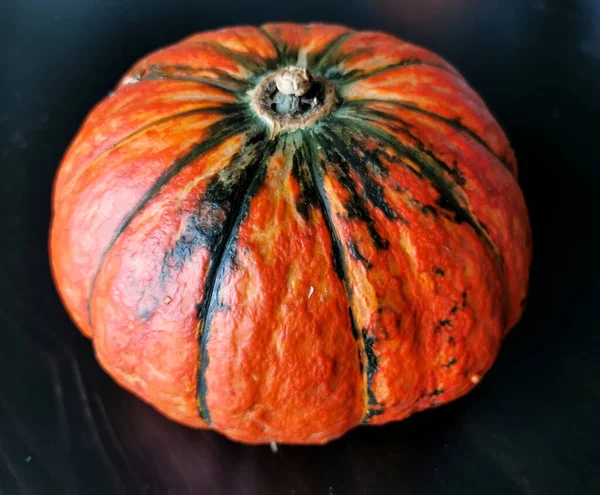 Small Orange Pumpkin Green Stripes Black Wooden Table Your Harvest — Stock Photo, Image