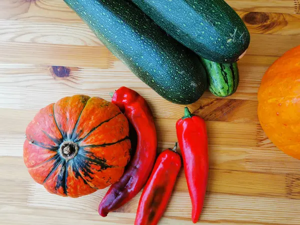 Two Small Orange Pumpkins One Green Stripes Three Red Peppers — Stock Photo, Image