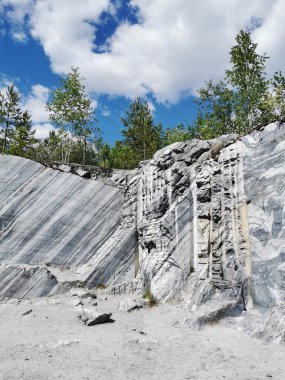 Güneşli bir yaz gününde Ruskeala Dağ Parkı 'nda pürüzsüz mermer parçalı İtalyan taş ocağı.
