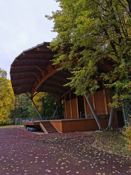 An outdoor wooden summer theater among the trees in the autumn park on the Elagin Island of St. Petersburg.